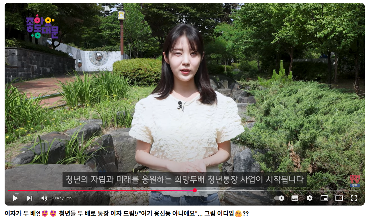 여성 리포터가 공원 앞에서 얘기하는 모습 