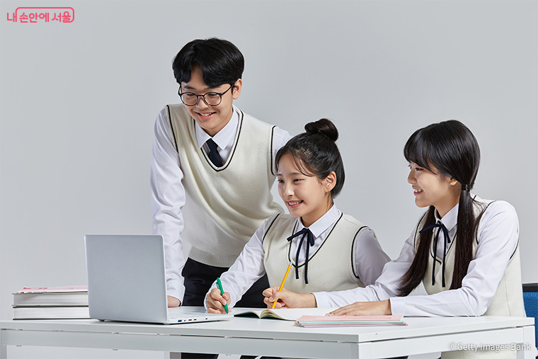 학생 3명이 교복을 입고 노트북을 함께 보면서 공부하는 모습